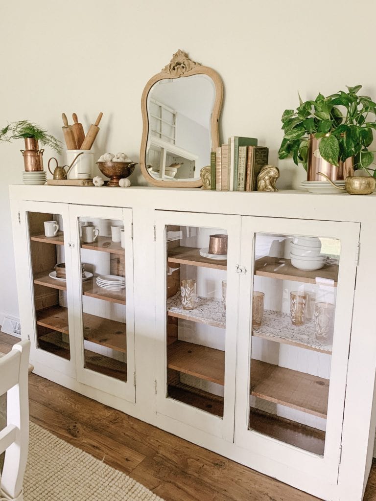 white cabinet with pine shelves used as a buffet in dining room