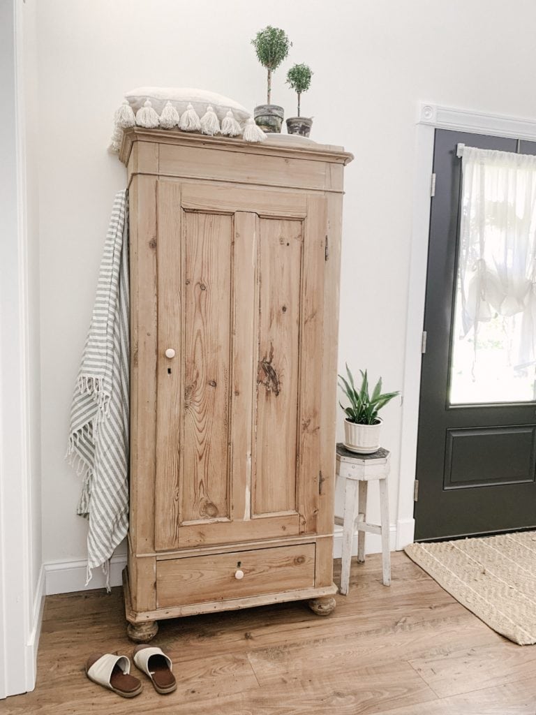 antique pine wardrobe used for coat closet in entryway