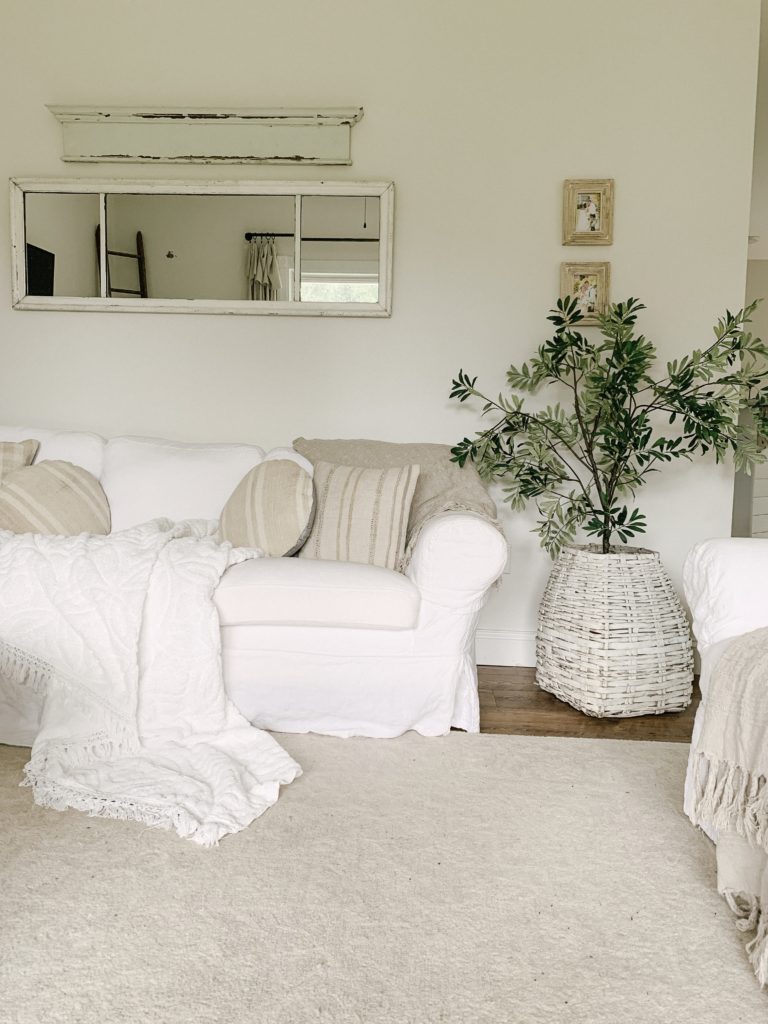 https://sarahjaneinteriors.blog/wp-content/uploads/2019/08/cozy-couch-with-olive-tree-in-antique-basket-768x1024.jpeg