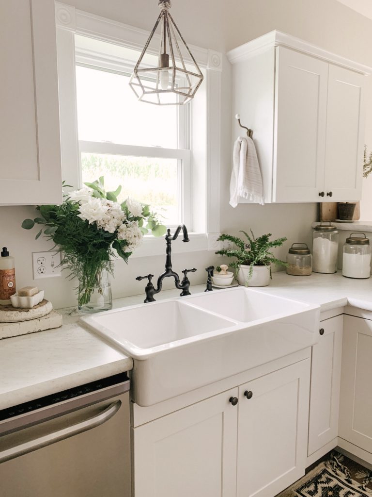 white farmhouse sink with towel on upper cabinet