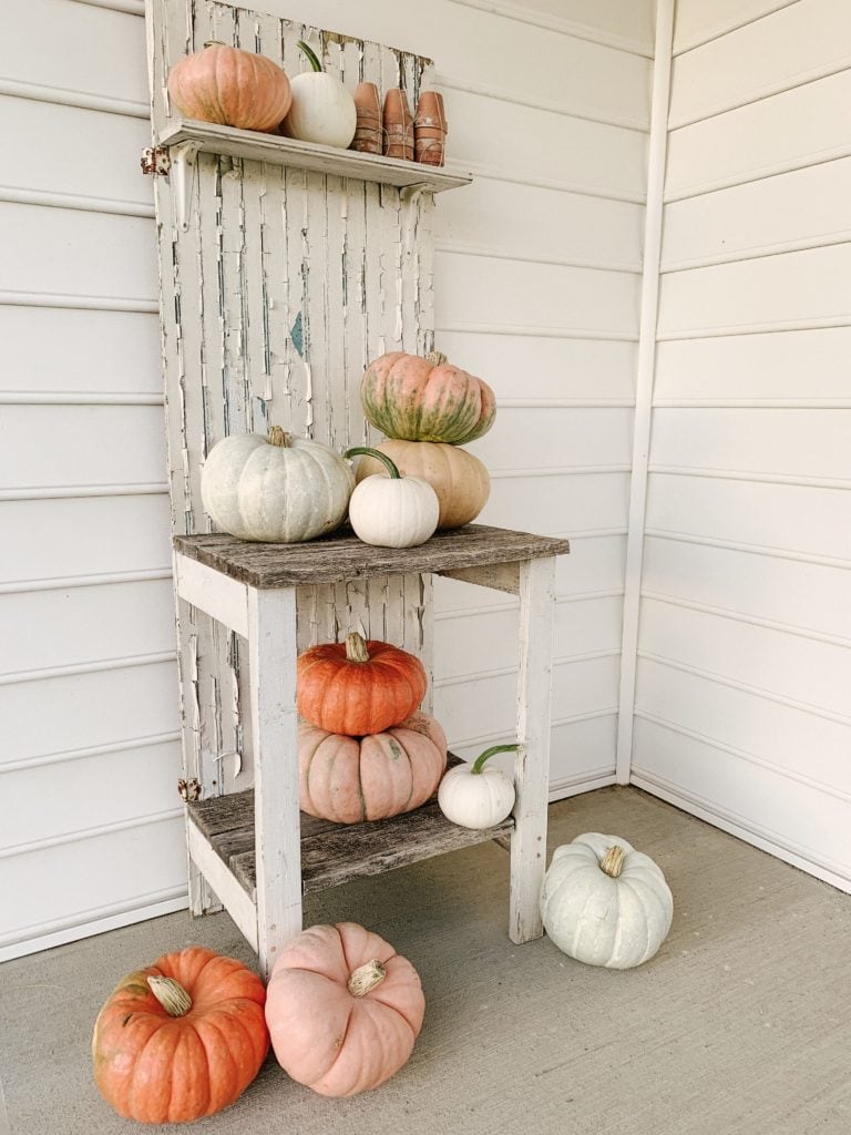 unique and colorful pumpkins on from porch potting bench area