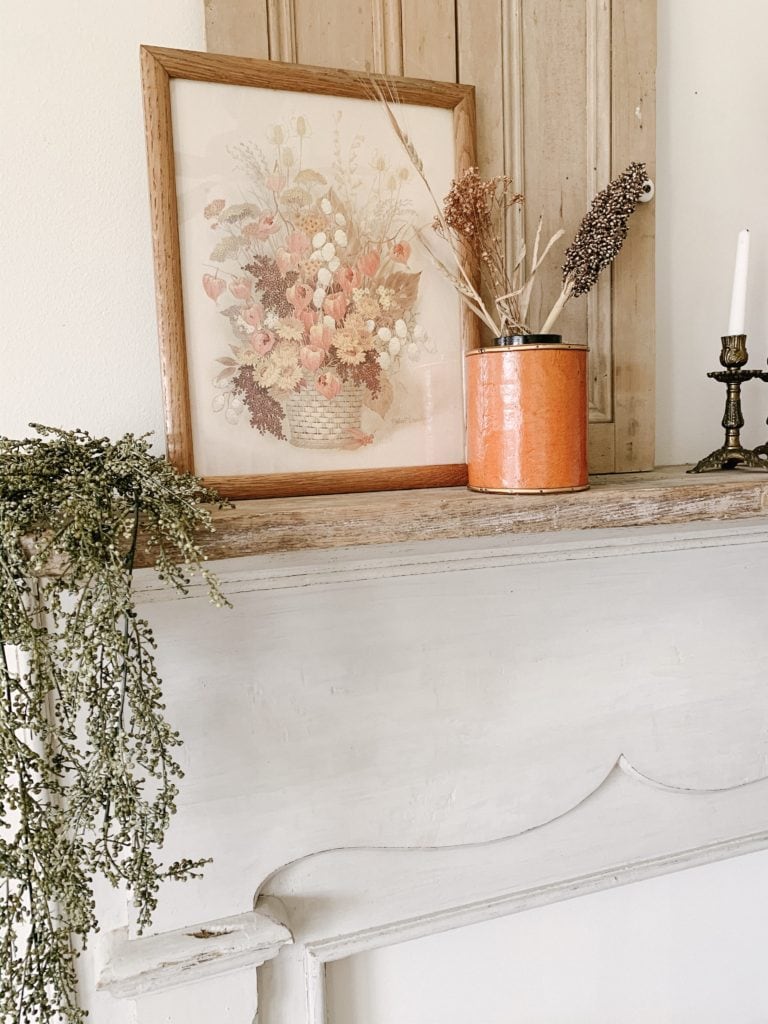 orange container with fall stems on a mantle