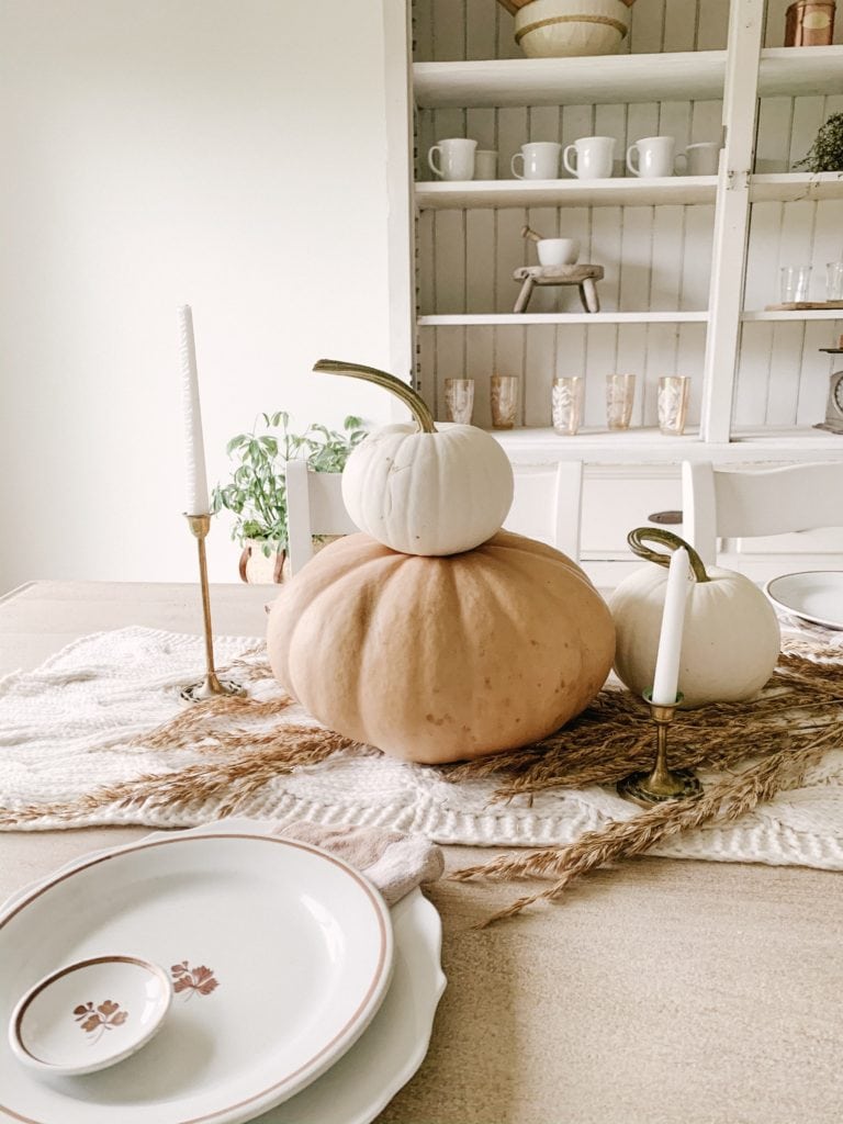 stacked pumpkins on table for pretty fall dining room centerpiece