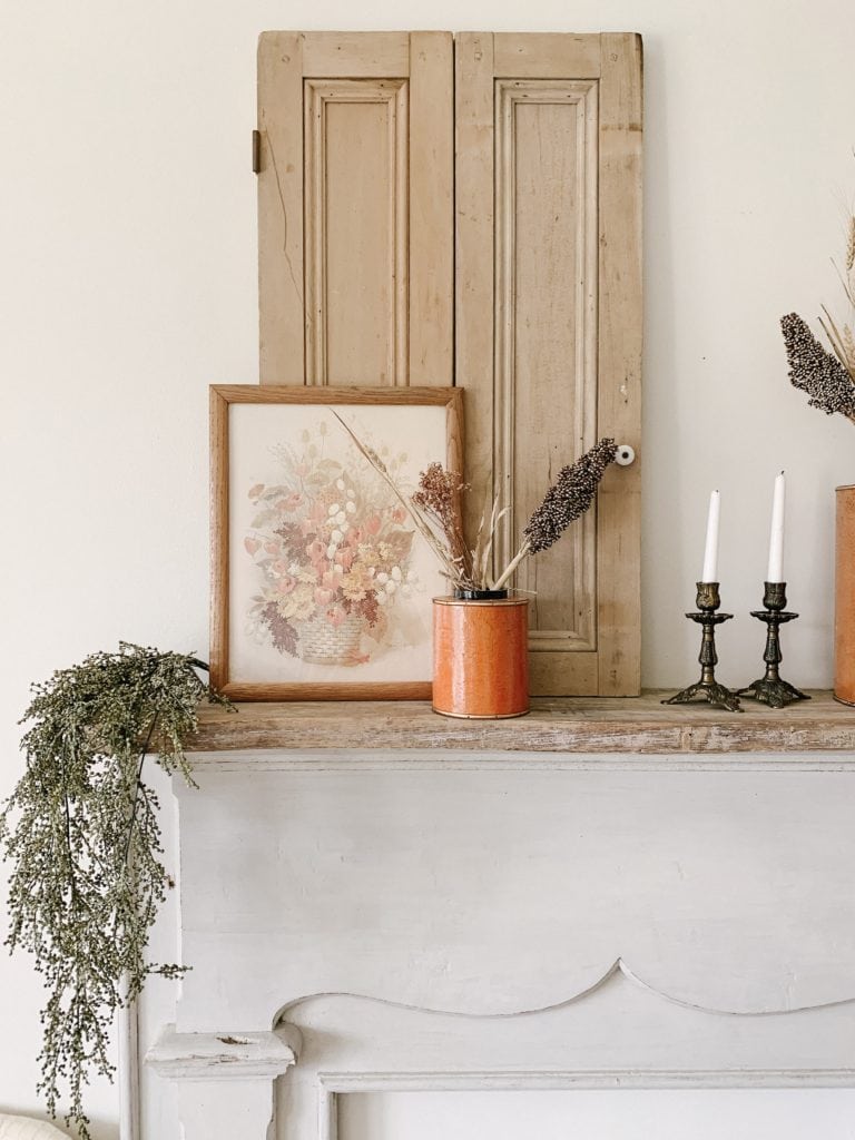 layering prints for fall decor on mantle ledge