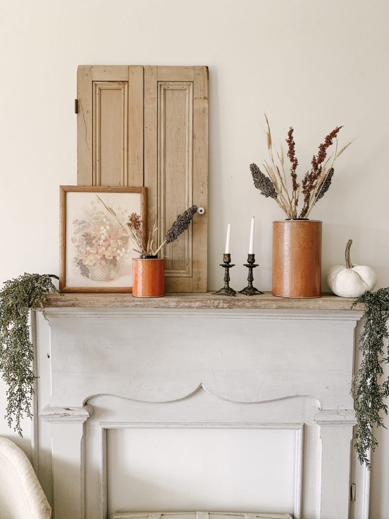 thrifted fall decor inspo on antique mantel in bedroom