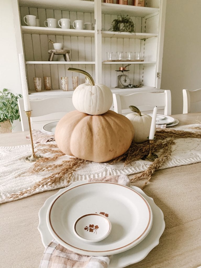 stacked pumpkins used as fall centerpiece on table
