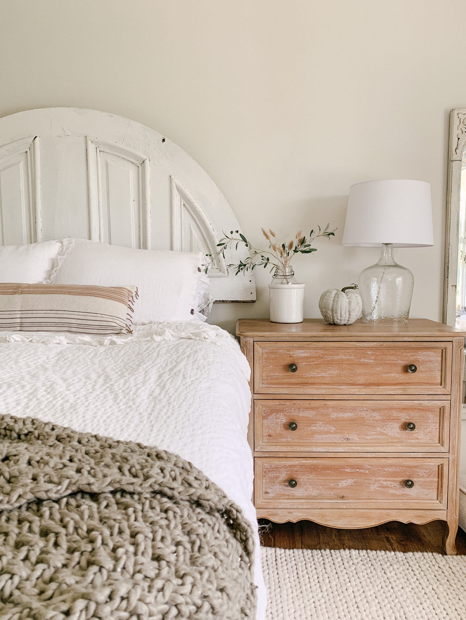 white farmhouse bedroom decorated for fall with earthy textured faux pumpkin